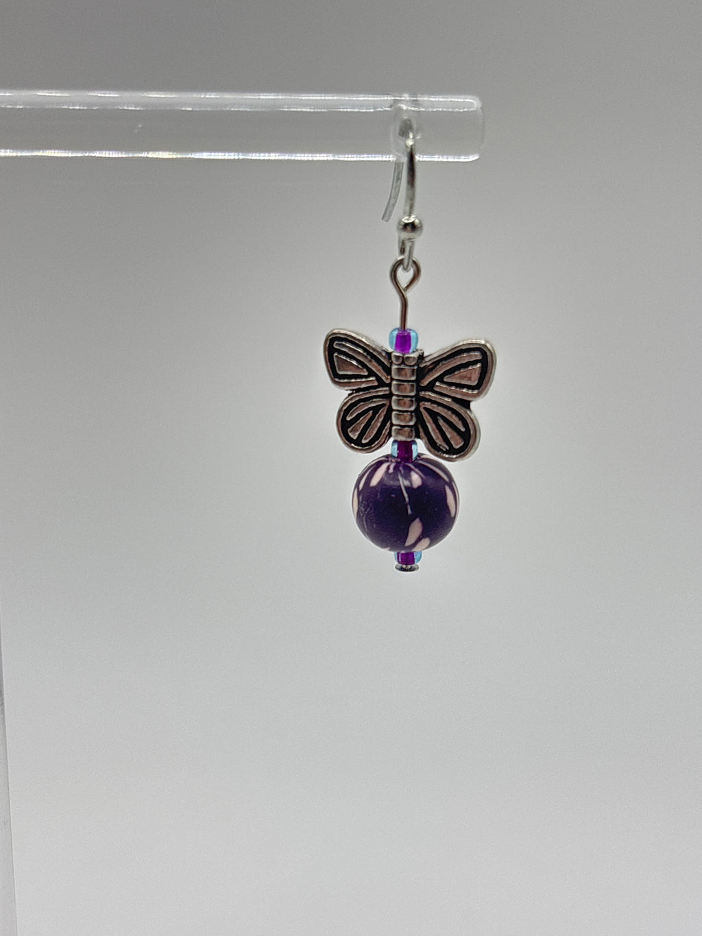 Silver tone butterfly with dark purple bead