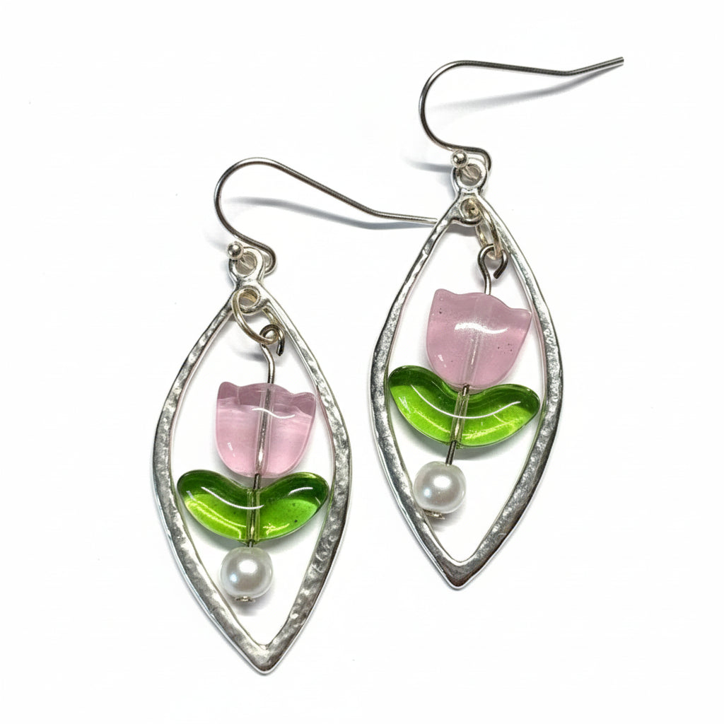 Silver earrings with pink and green floral designs on a decorative background