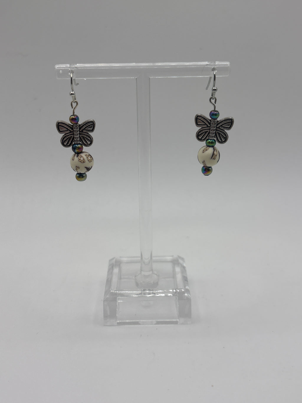 Silver tone butterfly on cream bead