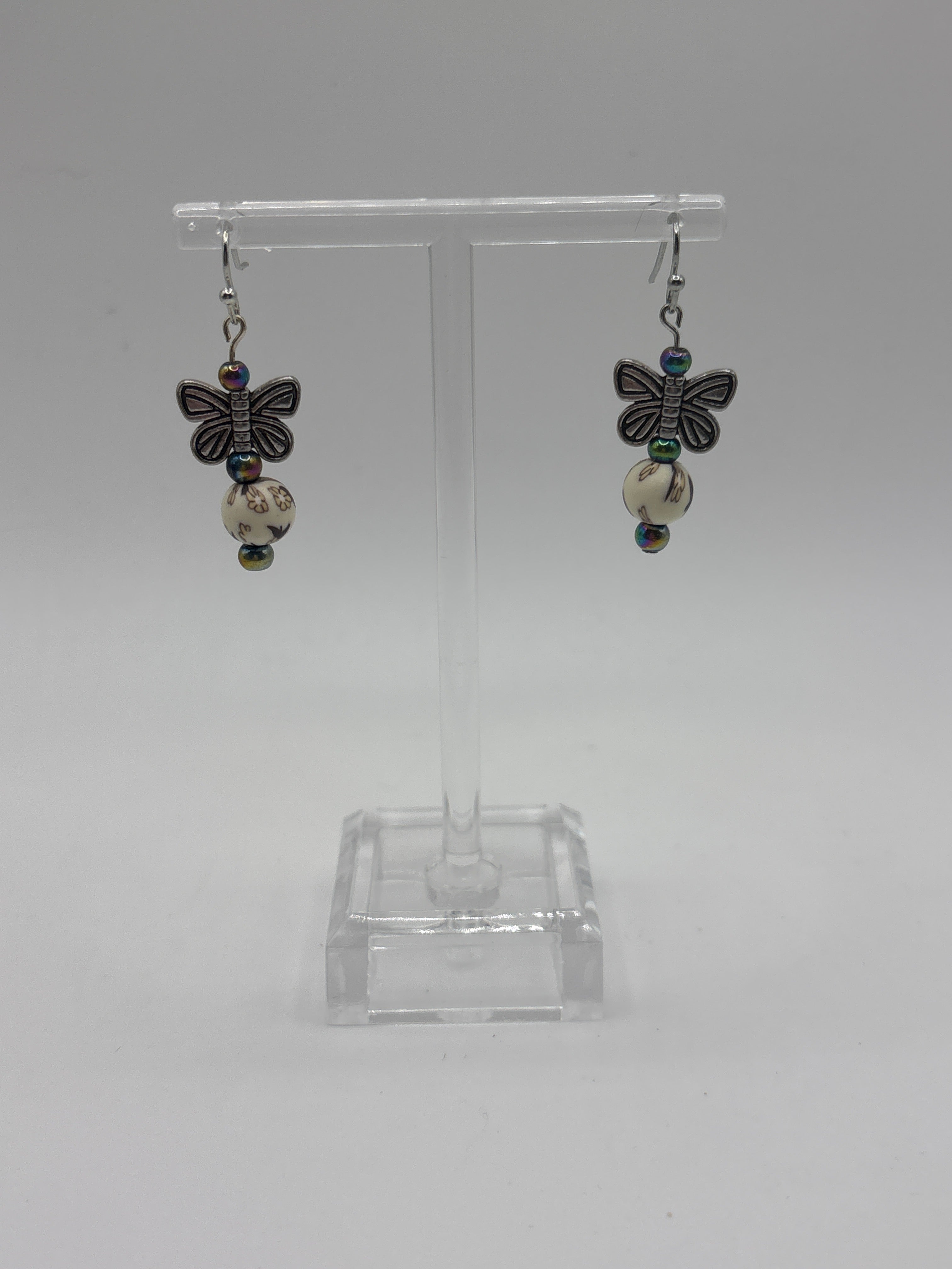 Silver tone butterfly on cream bead