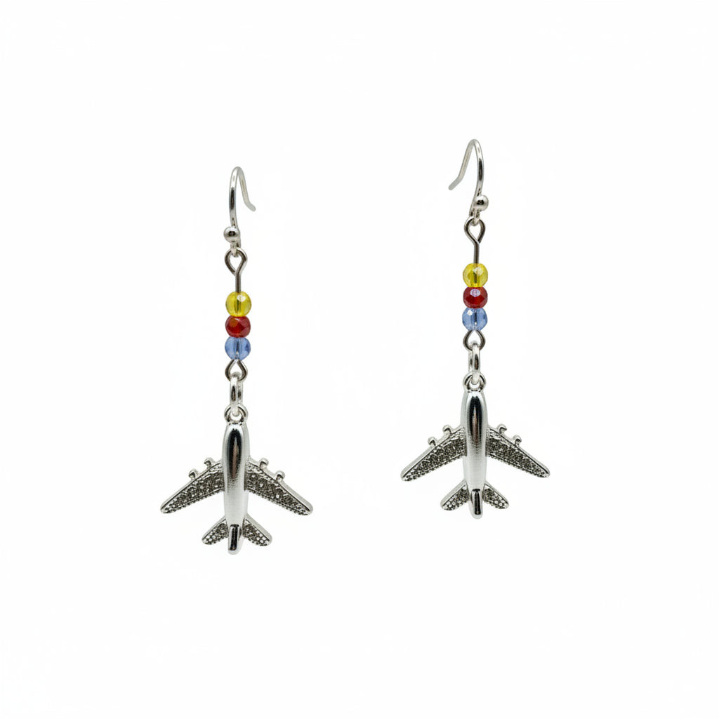 Pair of airplane-shaped earrings on a clear stand against a gray background
