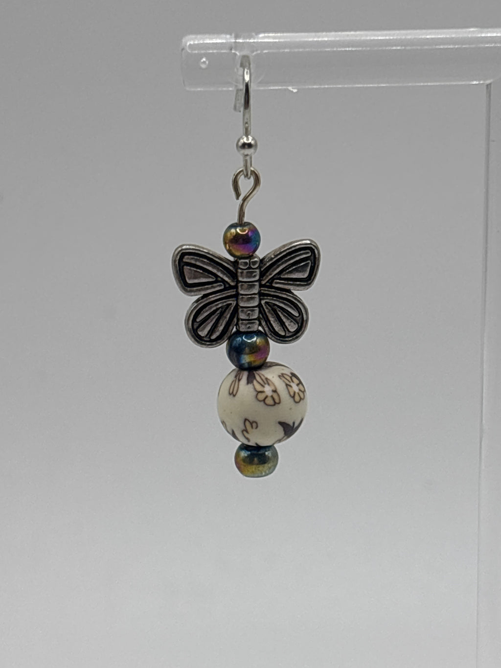 Silver tone butterfly on cream bead