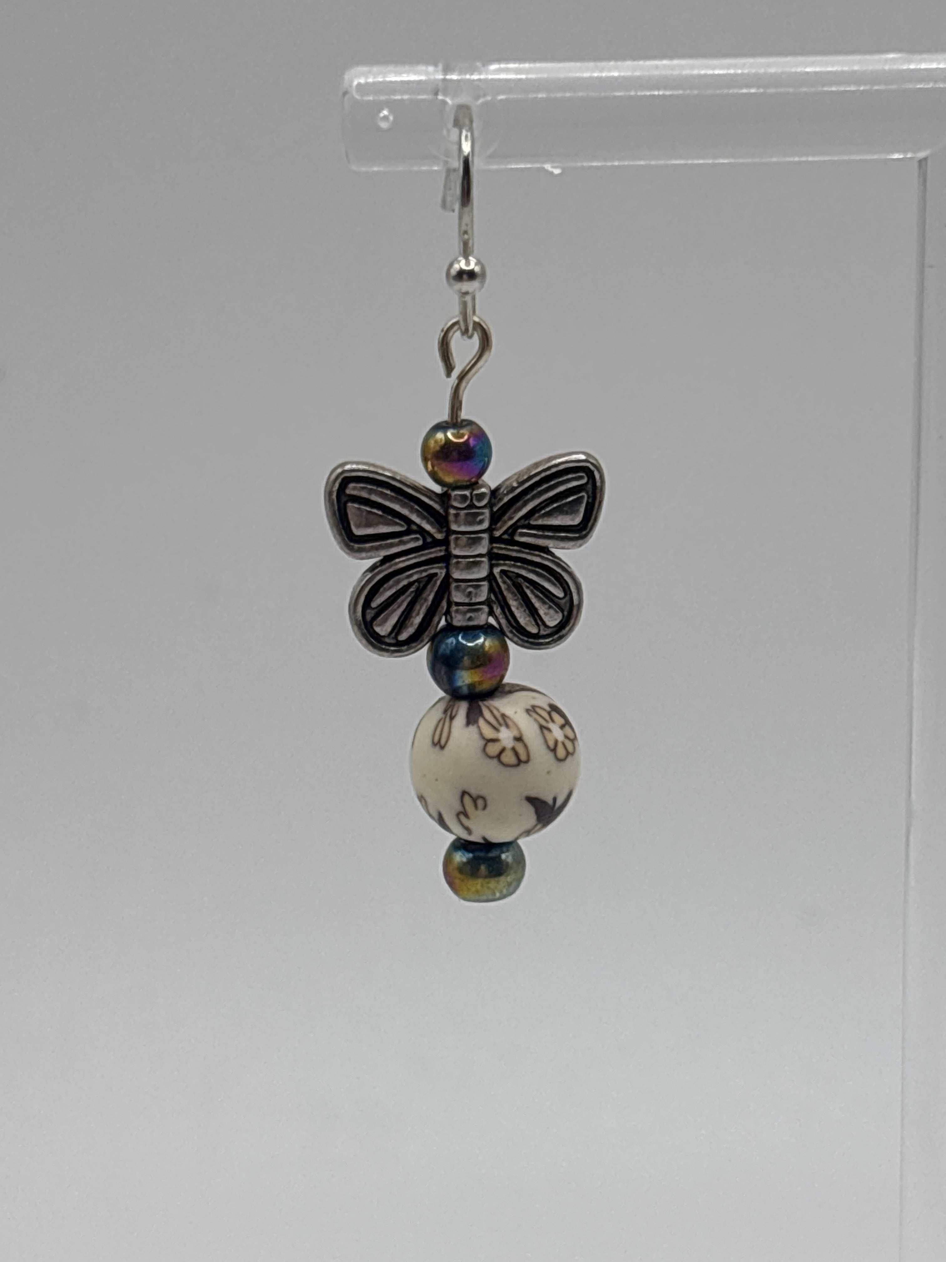 Silver tone butterfly on cream bead