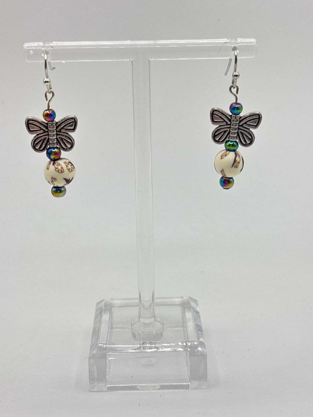 Silver tone butterfly on cream bead